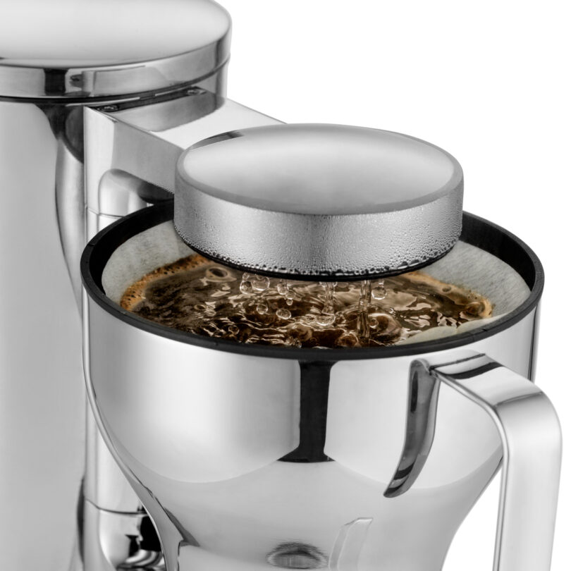 A close-up of the sleek Aarke Coffee System brewing coffee, with steam gently rising from the stainless steel top.