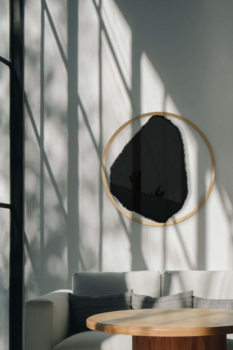 natural black stone wall sculpture in a living room with shadows on the wall