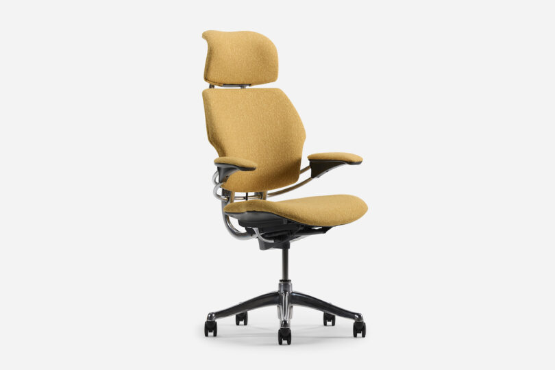 Office chair with mustard yellow upholstery, ergonomic design, adjustable armrests, and a headrest on a five-wheel base