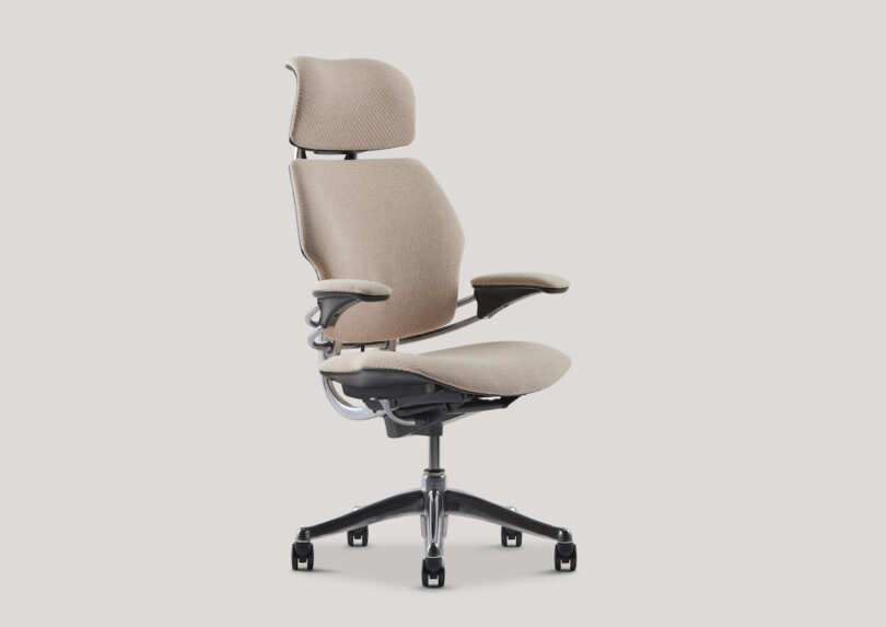 Ergonomic office chair with beige upholstery, adjustable headrest, armrests, and a five-wheel black base