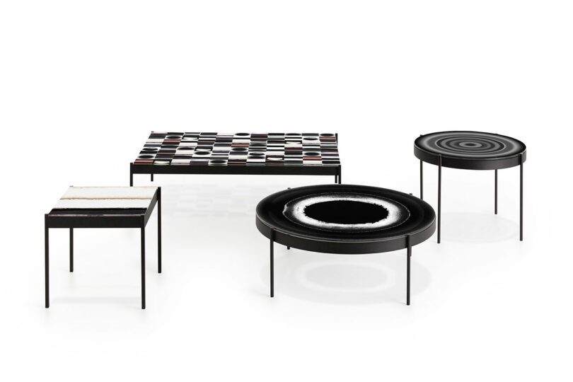 A set of four modern tables with geometric designs and minimalist metal legs is arranged on a white background.