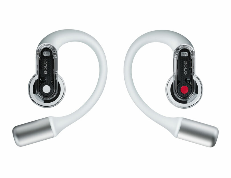 A pair of wireless Nothing Ear (open) earphones with transparent casings and ear hooks, featuring circular black touch controls labeled "NOTHING.