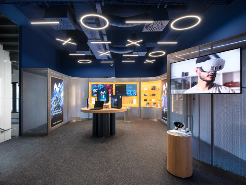 Modern tech store interior with digital displays, VR equipment, and sleek lighting.